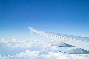 Aile d& 39 avion au-dessus des nuages vu à travers la fenêtre