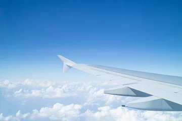 Papier Peint photo autocollant Avion Aile d& 39 avion au-dessus des nuages vu à travers la fenêtre
