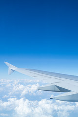 Fototapeta na wymiar Airplane wing above cloud seen through window