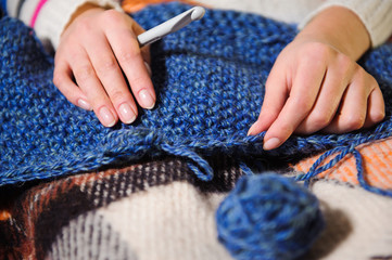 Close-up of woman hands knitting colorful wool yarn.