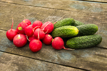 Fresh cucumbers and radish on rustic wooden table
