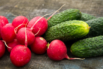 Fresh cucumbers and radish on rustic wooden table