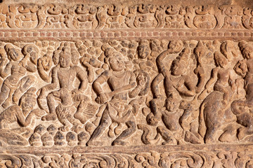 Battle scene with jumping warriors in crow of soldiers, carved wall inside the 7th century temples in Pattadakal, India. UNESCO World Heritage site