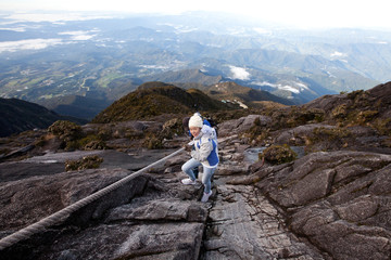 Naklejka premium The Woman is hiking on Kinabarull mountain