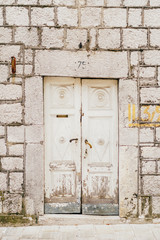 Fototapeta na wymiar Old white doors. Wood texture. Old shabby, irradiated paint