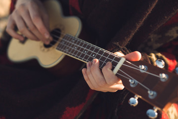 Fototapeta premium Ukulele closeup - woman playing on a little guitar