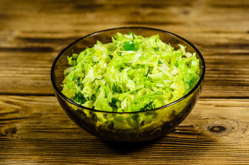 Salad with savoy cabbage and green onion in a bowl