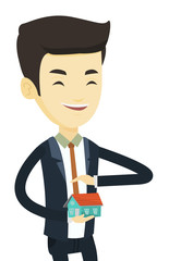 Insurance agent protecting model of the house.