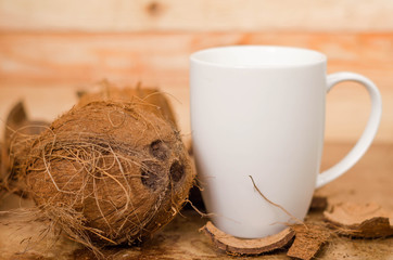 Tasty cocktail in white cup with coconut on wooden vintage table background