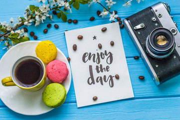 Stil life with macarons and coffee on the wooden background