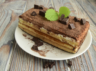 Tiramisu is classical Italian cake on the basis of a biscuit. Cake is on a wooden table.