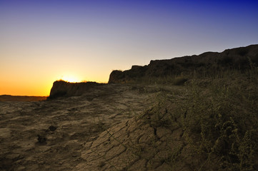 Evening landscape with dry cracked earth