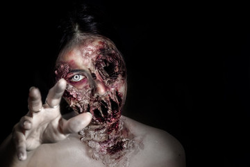  horrible scary zombie girl on black background with copyspace