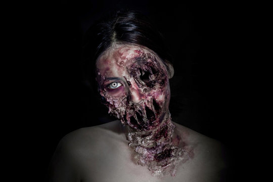  horrible scary zombie girl on black background with copyspace