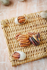 Nice pecan nuts over pink plastic board.