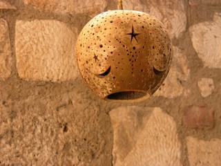 Traditioneller Lampenschirm im osmanischen Stil vor altem Mauerwerk aus Naturstein in Beige und...