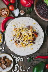 Vegetables, beans and cheese over tortilla bread - vegetarian mexican salad tacos.