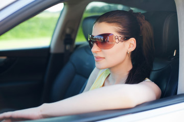 Beautiful young woman enjoying in a car ride.
