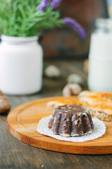 Chocolate cake on wooden board over dark background.
