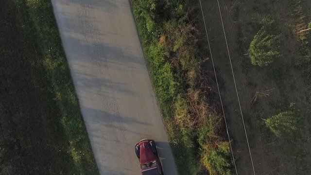 Aerial view of red oldtimer. Red oldtimer moving on the road.Oldtimer is driving on the asphalt road . Aerial top view