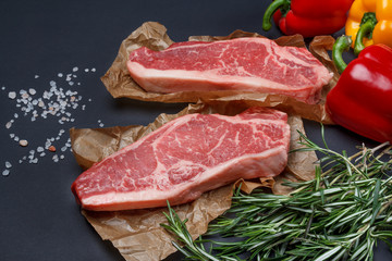 Striploin steak with sweet pepper, salt and rosemary background