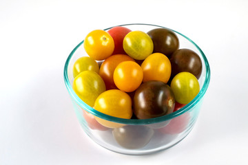 Closeup on rainbow cherry tomatoes in glass bowl on white background cherry tomatoes