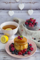 delicious pancakes on wooden table with fruits