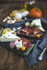 Slices of Delicious Prosciutto with capers, olives and cheese