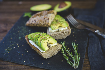 Avocado sandwich over rustic background 