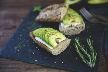 Avocado sandwich over rustic background 