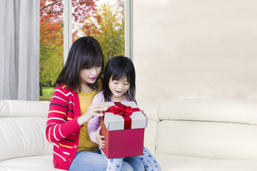 Obraz premium Cute daughter and mother open give box
