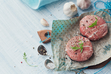 Organic raw ground beef wrapped in strips of bacon.