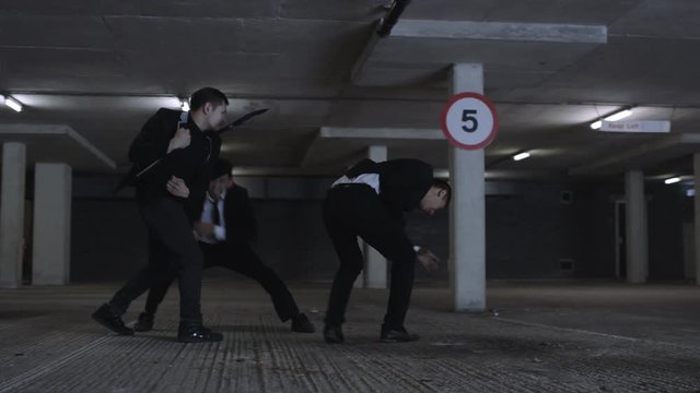  Asian gangster fighting in dark parking lot with members of a rival gang