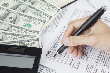 Obraz premium Hands of worker writes on the tax form
