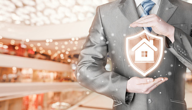 House protection and insurance. Home shield. Real estate safety. Blurred mall background.