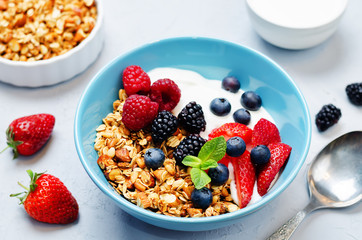 Healthy breakfast with granola, greek yogurt, berries and milk