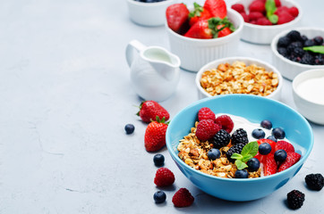 Healthy breakfast with granola, greek yogurt, berries and milk