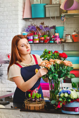 young girl working in a flower shop, Florist woman makes a bouquet