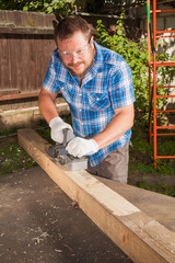 Carpenter chipping the wooden plank