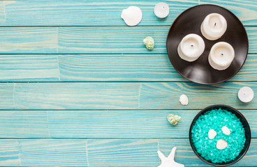 Spa composition. Candles, sea shells and stars, flowers, sea salt on on turquoise wooden background. Flat lay, mock up. top view
