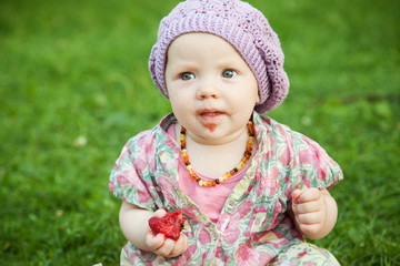 Child with strawberry in nature