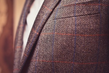 Classic tweed men's jacket with closeup on wool fabric texture. Fashion and lifestyle. Portrait of a buisinessman in a jacket. Copy space. - obrazy, fototapety, plakaty