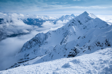 Severe mountains ridge covered by snow in the shiny sunny day