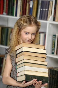 Girl with a pile of books in hands.