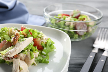 Plate with chicken salad and grapes on table