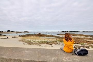 Une jeune femme pratique la randonnée sur le sentier de randonnée GR32 du Trégor en Bretagne