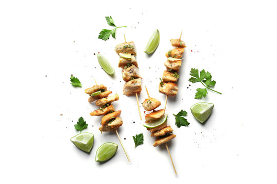 Skewers of delicious tequila lime chicken on white background