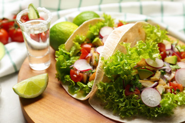 Delicious tacos with tequila lime chicken on wooden board