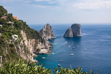 Obraz premium View of cliff coast of Capri Island with famous faraglioni rocks
