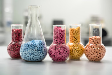 Multicolored pills in glass flasks